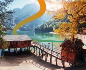 a wooden dock sitting next to a lake surrounded by mountains