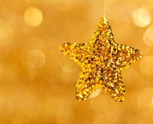 a gold star ornament hanging from a string