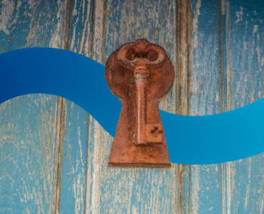 a key on a wooden door with a blue ribbon around it