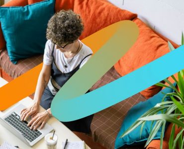 a person sitting on a couch using a laptop