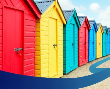 a row of colorful beach huts sitting on top of a sandy beach