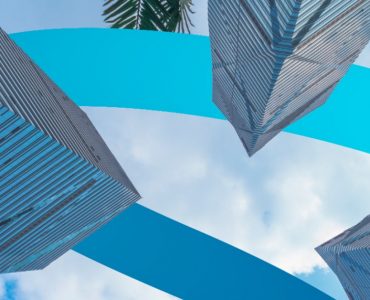 a group of tall buildings next to a palm tree