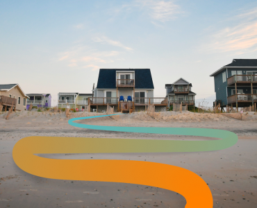 a row of houses on a sandy beach