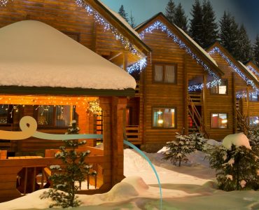 a house covered in snow with Christmas lights