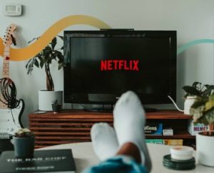 a person's feet resting on a table in front of a television