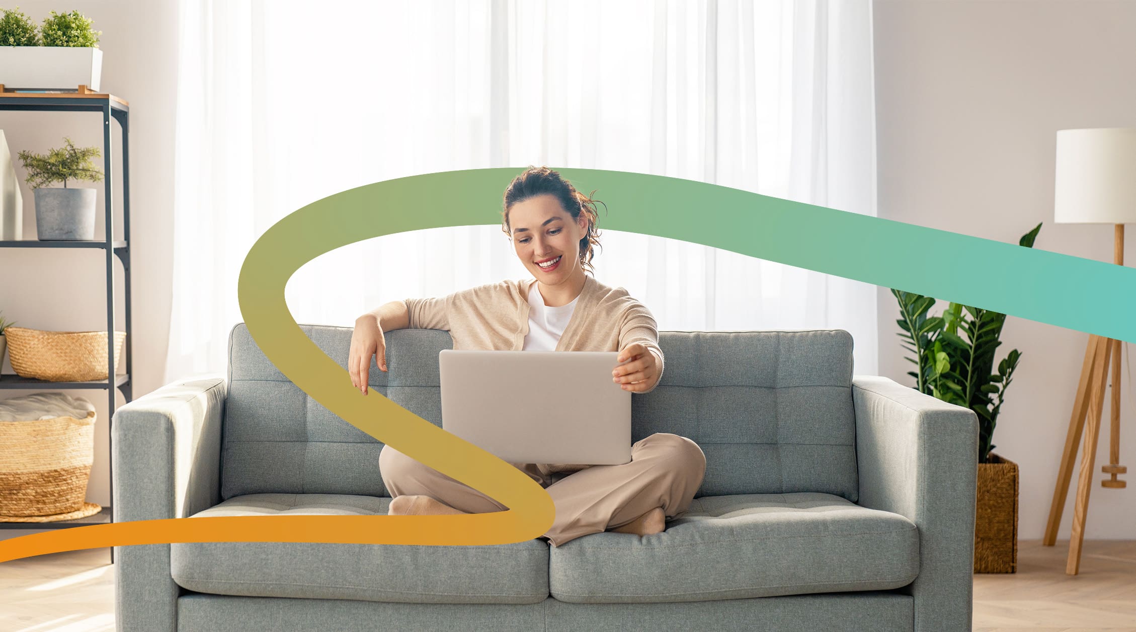 a woman sitting on a couch using a laptop